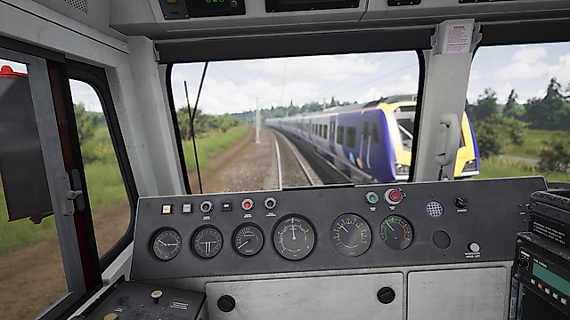 First-person driver view from inside a locomotive cab showing the control panel and an oncoming passenger train.